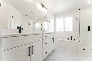 Full bathroom featuring a stall shower, double vanity, a bath, marble finish floors, and recessed lighting