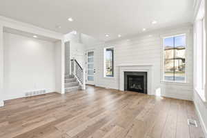 Unfurnished living room with crown molding and light hardwood / wood-style floors