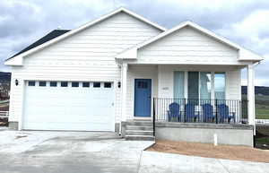 View of front of property featuring a garage and covered porch