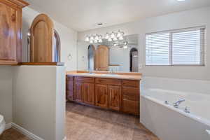 Bathroom featuring ceiling fan, vanity, and a bath