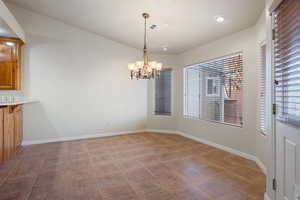 Unfurnished dining area with plenty of natural light and a notable chandelier