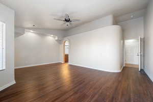 Unfurnished room with ceiling fan, dark hardwood / wood-style floors, and vaulted ceiling