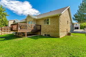 Back of property with central AC unit, a patio area, a yard, and a wooden deck