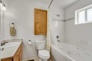 Full bathroom featuring tile patterned floors, toilet, shower / bath combo with shower curtain, and vanity