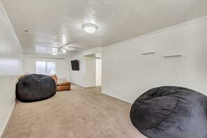 Sitting room featuring ceiling fan, light carpet, and ornamental molding