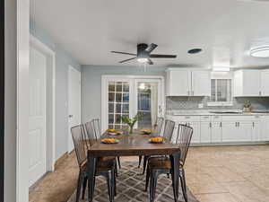 Dining room with ceiling fan, sink, light tile patterned floors, and french doors