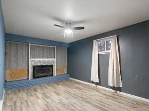 Unfurnished living room featuring ceiling fan and light wood-type flooring