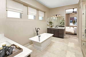 Bathroom featuring vanity, ceiling fan, and plus walk in shower