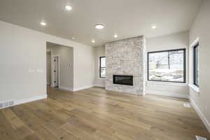 Unfurnished living room featuring wood-type flooring and a fireplace