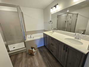 Full bathroom with vanity, toilet, independent shower and bath, and wood-type flooring