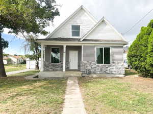 View of front of house featuring covered porch and a front lawn