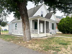 View of front facade featuring a front yard and covered porch