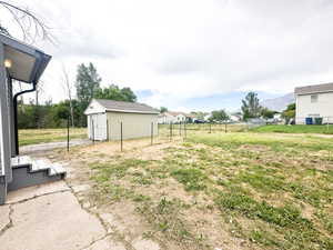 View of yard with a mountain view and a storage unit