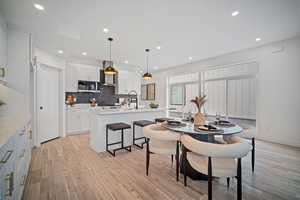 Dining space with light wood-type flooring and sink