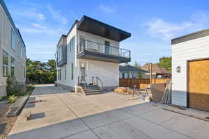 Back of property featuring a balcony and a patio