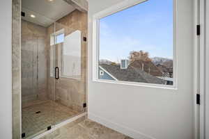 Bathroom with tile patterned flooring, a healthy amount of sunlight, and a shower with shower door