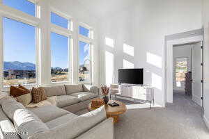 Living room featuring a mountain view, a high ceiling, and carpet