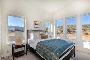 Bedroom featuring lofted ceiling and a mountain view