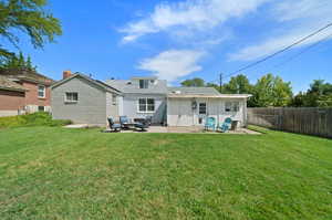 Back of house with a yard and a patio area