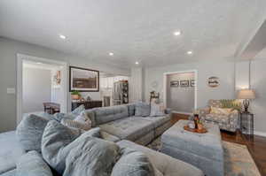 Living room with a textured ceiling and hardwood / wood-style floors