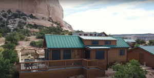Back of property with a standing seam roof, a wooden deck, and metal roof