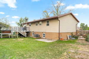 Rear view of house featuring cooling unit, a yard, a patio area, and a deck