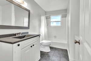 Full bathroom featuring vanity, toilet, tile patterned floors, and shower / bathtub combination with curtain