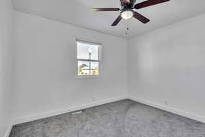 Spare room featuring carpet flooring and ceiling fan