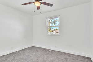 Carpeted empty room featuring ceiling fan