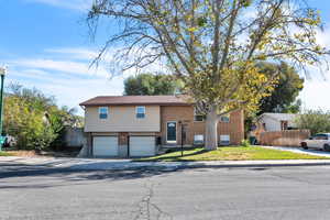 Raised ranch featuring a front lawn and a garage