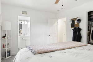 Carpeted bedroom featuring a closet, ceiling fan, connected bathroom, and sink