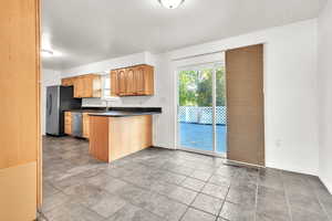 Kitchen featuring tile patterned floors, sink, kitchen peninsula, and stainless steel appliances