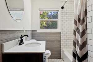 Full bathroom with vanity, toilet, shower / tub combo, and tile patterned floors