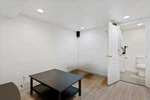 Interior space featuring light wood-type flooring and a textured ceiling