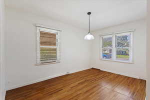 Empty room with hardwood / wood-style flooring