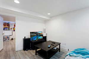 Living room featuring a textured ceiling and light hardwood / wood-style floors