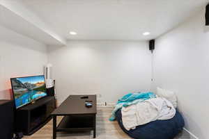 Living room with a textured ceiling and wood-type flooring