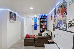 Living area featuring light wood-type flooring and a textured ceiling