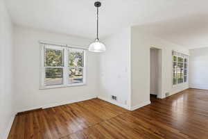 Empty room featuring dark hardwood / wood-style flooring