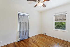 Unfurnished room with ceiling fan and hardwood / wood-style flooring