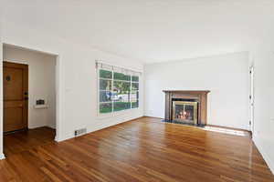 Unfurnished living room with dark wood-type flooring