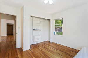 Unfurnished bedroom featuring a closet and hardwood / wood-style flooring