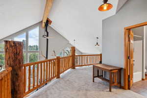 Corridor featuring carpet flooring, high vaulted ceiling, and beam ceiling