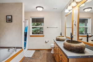 Full bathroom featuring independent shower and bath, toilet, and vanity