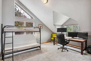 Office with vaulted ceiling and carpet