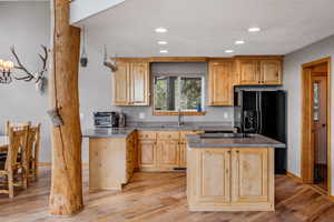 Kitchen featuring a kitchen island, sink, and light hardwood / wood-style flooring