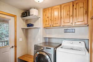 Washroom with a textured ceiling, washing machine and dryer, and cabinets