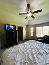 Bedroom with a textured ceiling, carpet flooring, and ceiling fan