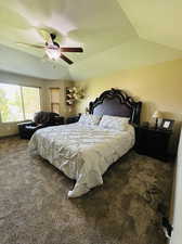 Carpeted bedroom featuring lofted ceiling and ceiling fan