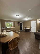 Dining space featuring a textured ceiling and dark hardwood / wood-style floors